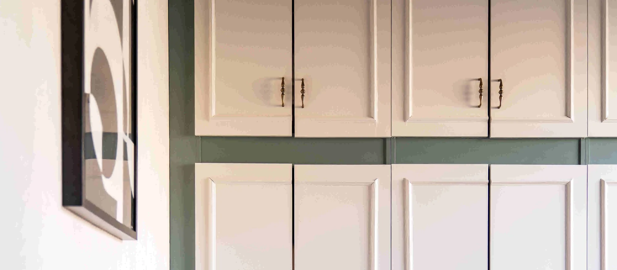 Kastenwand met crèmekleurige paneeldeuren en messing grepen